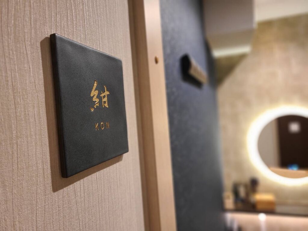 休憩ルーム「紺」の入口に設置した金色の文字のプレートと、奥に見える丸い鏡