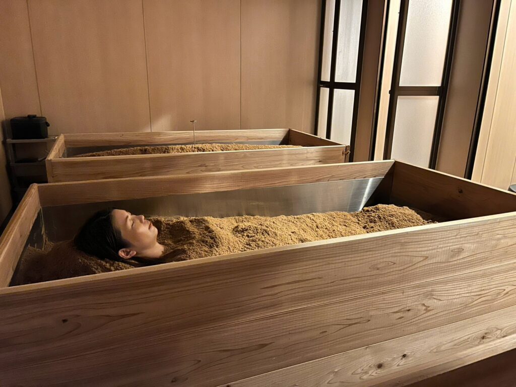 ヒノキの浴槽（桶）が並ぶ酵素浴の浴室と、障子から差すやわらかなあかり